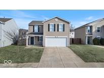 Two-story house with tan siding, a white garage door, and a well-maintained lawn at 9238 Bainbridge Dr, Camby, IN 46113