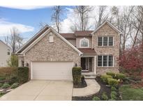 Charming two-story brick home with an attached two-car garage and well-manicured front yard at 10402 Shakamak Way, Indianapolis, IN 46239