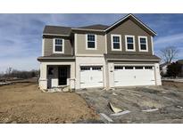 Two-story home featuring a two-car garage, tan and brown siding and a white brick facade at 4384 Risen Star Way, Bargersville, IN 46106