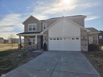 Charming two-story home features a two-car garage, brick accents and manicured landscaping at 5619 Beale St, Plainfield, IN 46168