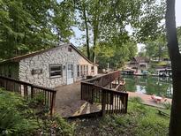 Charming stone home nestled in trees with private deck and lake access offers serene outdoor living and stunning views at 7018 Drum Dr, Nineveh, IN 46164
