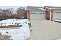 Brick ranch home with attached garage and snow-covered landscaping at 8042 Hazen Way, Indianapolis, IN 46216