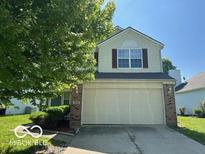 Inviting two-story home featuring a large two car garage and manicured landscaping at 11663 Congressional Ln, Indianapolis, IN 46235