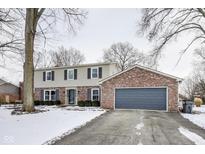 Two-story house with brick and siding exterior, attached garage, and snowy front yard at 1601 Bowman Dr, Greenfield, IN 46140