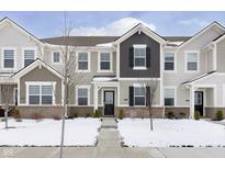 Two-story townhome with brick and siding exterior, snow-covered landscaping, and a walkway at 1965 Mildred Rd, Westfield, IN 46074