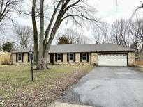Ranch home with stone exterior, attached garage, and mature trees at 2526 Pleasant W Way, Carmel, IN 46280