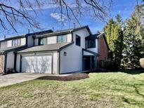 Charming two-story home with attached garage and freshly manicured lawn on a sunny day at 8207 Shorewalk Dr, Indianapolis, IN 46236