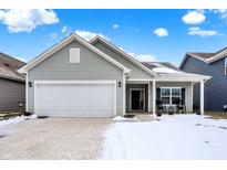 Gray house with white garage door and porch, rocking chairs, and snowy yard at 2439 Bridlewood Dr, Franklin, IN 46131