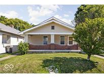 Charming single-story home featuring a cozy front porch and a well-maintained lawn at 3614 E New York St, Indianapolis, IN 46201