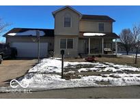 Two-story house with attached garage and covered porch. Landscaped yard with snowy patches at 4651 Maplelawn Dr, Columbus, IN 47203