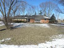 Brick ranch home with snow-covered lawn and mature trees at 5420 Skyridge Dr, Indianapolis, IN 46250