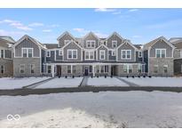Three-story townhouses with gray siding, snow-covered yards, and charming front porches at 5763 Cr W 750 N, McCordsville, IN 46055