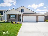 Beautiful one-story brick home with a well-manicured lawn and a spacious three-car garage at 6033 Granby Dr, Whitestown, IN 46075