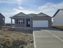 Charming single-story brick home featuring a covered entryway and attached two-car garage at 6047 Granby Dr, Whitestown, IN 46075