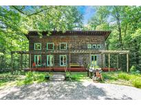 Stunning home exterior surrounded by lush greenery, featuring a spacious front porch and unique wood shingle siding at 6377 N Tutterow Rd, Monrovia, IN 46157