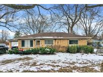 Brick ranch house with a well-maintained lawn and mature trees at 6621 W 12Th St, Indianapolis, IN 46214