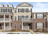 Brick and tan three-story townhome with front balcony at 7161 Caversham Pl, Indianapolis, IN 46278