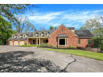 A stately brick home featuring a three-car garage and manicured landscaping at 8602 Frontgate Ln, Indianapolis, IN 46256