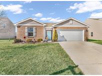 Charming brick home with a well-manicured lawn, delightful landscaping, and a light blue front door at 1710 Elderberry Dr, Indianapolis, IN 46234