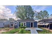 Charming home featuring a cozy front porch and complemented by mature trees against a blue sky at 2317 Fowler St, Anderson, IN 46012