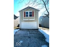 Tan two-story house with a white garage door and orange shutters at 2507 Redland Ln, Indianapolis, IN 46217