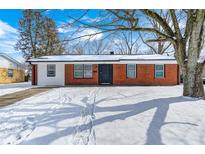 Charming brick home with a well-maintained yard and beautiful tree in a winter setting at 3647 Richelieu Rd, Indianapolis, IN 46226