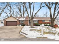 Brick ranch house with attached garage, driveway, and mature trees at 3909 S Lasalle St, Indianapolis, IN 46237