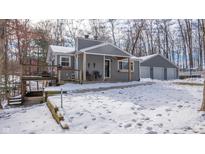 Gray house with detached garage, large deck, and snowy yard at 55 Peavine Rd, Martinsville, IN 46151