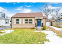 Cute ranch home with a blue door and landscaped lawn at 5845 Villa Ave, Indianapolis, IN 46227