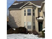 Tan brick and vinyl sided home with a bay window and snowy front yard at 706 Shagbark Ct, Plainfield, IN 46168