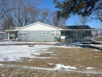 Ranch home with gray siding, snow-covered yard, and accessible ramp at 9710 E 38Th St, Indianapolis, IN 46235