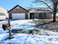Brick ranch home with attached garage and snow-covered yard at 123 S Morris Blvd, Bargersville, IN 46106