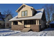 Charming Craftsman home with brick detailing and snow-covered lawn at 336 N Whittier Pl, Indianapolis, IN 46219