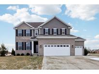 Two-story home with gray siding, brick accents, and a three-car garage at 373 Brianne Ln, Danville, IN 46122