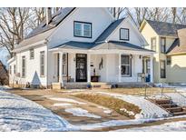 White house with solar panels, porch, and snow-covered yard at 3816 Rookwood Ave, Indianapolis, IN 46208
