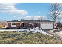Brick ranch home with attached garage, landscaping, and a spacious front yard at 4817 W Quail Run W Dr, New Palestine, IN 46163