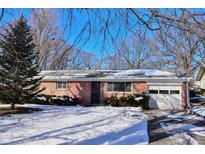 Brick ranch house with snow-covered yard and attached garage at 6628 E Michigan St, Indianapolis, IN 46219