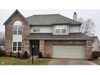 Two-story brick home with gray siding, attached garage, and landscaping at 8660 Lantern Farms Dr, Fishers, IN 46038