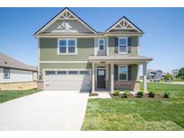 Charming two-story home with a two-car garage and a well-manicured lawn at 8703 Duncan St, Fortville, IN 46040