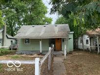 Green bungalow home with front porch and small yard at 1035 S Tremont St, Indianapolis, IN 46221