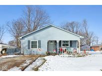 Cute blue house with front porch, winter landscaping, and snowy yard at 1650 Stout St, Martinsville, IN 46151