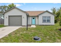 Charming ranch home with gray siding, attached garage, and a light teal front door at 3917 Ireland Dr, Indianapolis, IN 46235