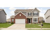 Charming two-story home with a red brick and gray siding exterior, complemented by a well-manicured lawn and a driveway at 5136 Charmaine Ln, Plainfield, IN 46168