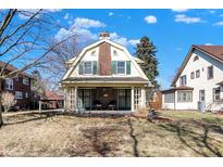 Charming two-story home with a unique roofline, brick chimney, covered porch, and inviting curb appeal at 5210 E Pleasant Run Parkway North Dr, Indianapolis, IN 46219