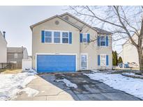 Beige two-story house with blue garage door, snow on ground at 10069 Boysenberry Dr, Fishers, IN 46038