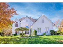 Beautiful two-story home with a well-manicured lawn and mature trees displaying vibrant fall colors at 1535 Cricklewood Way, Zionsville, IN 46077