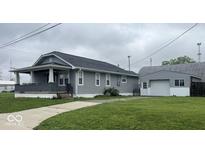 Charming single Gathering home with an inviting front porch and detached garage, perfect for storage and hobbies at 18 S Franklin St, Greenfield, IN 46140
