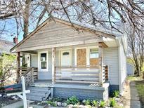 Modest home showcasing a porch and faded gray siding at 817 N Linwood Ave, Indianapolis, IN 46201