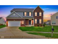 Inviting two-story brick home featuring a well-manicured lawn and attached two-car garage at 1284 Jesse Ct, Greenwood, IN 46143