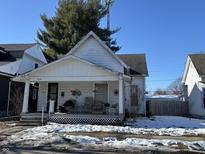 White house with porch, partially covered in snow, needs some repairs at 1620 Union St, Columbus, IN 47201